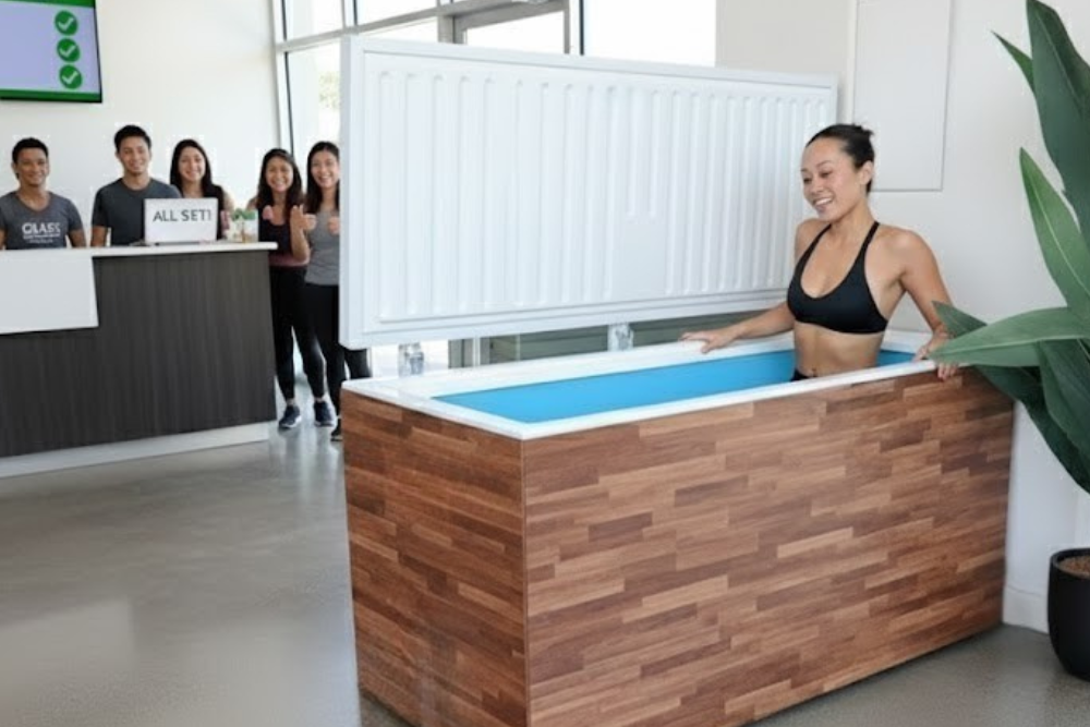 woman sitting in a fire cold plunge tub at her wellness studio